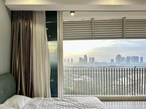 a bedroom with a window with a view of the city at Encorp Marina Family Suites Legoland 1B1B in Iskandar Puteri