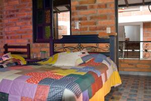 a bedroom with a colorful bed in a brick wall at Hotel Posada La Porra in Concordia