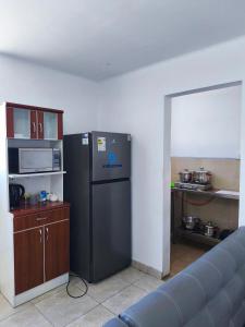 a kitchen with a black refrigerator in a room at Minidepartamento en el centro de Tacna in Tacna