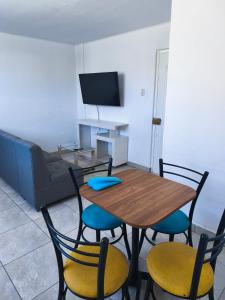 a dining room with a table and chairs and a couch at Minidepartamento en el centro de Tacna in Tacna