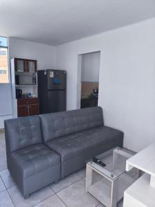a living room with a black couch and a kitchen at Minidepartamento en el centro de Tacna in Tacna +12 photos