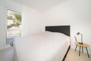 a white bedroom with a large bed and a window at La Vila - Bolnou Seaviews in Villajoyosa +37 photos
