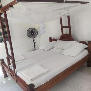 a bedroom with a canopy bed with white pillows at Sancanka Nungwi in Nungwi