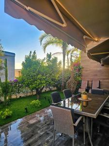a patio with a table and chairs and a garden at Villa 60 Olea Residence in Dhërmi