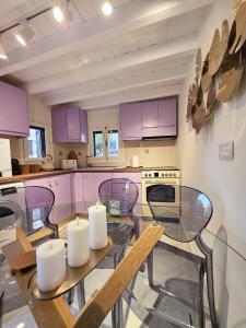 a kitchen with purple cabinets and a glass table with candles at Barbarian in Rhodes Town +31 photos