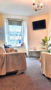 a living room with a couch and a table at Cozy Central Apartment in Inverness