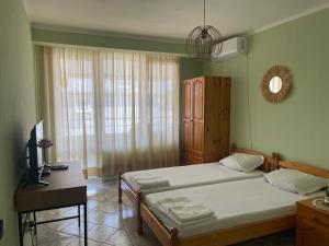 a bedroom with two beds and a desk and a television at KudevApartment1 in Nesebar