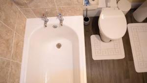 a bathroom with a white tub and a toilet at Cozy Central Apartment in Inverness +14 photos