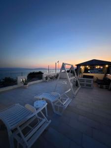 a patio with two lounge chairs and a swing at SeaView Villa Kariani in Ofrínion