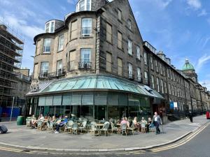 a group of people sitting at tables outside of a building at Central Edinburgh Prime Luxury in Edinburgh