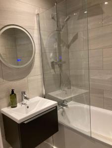 a bathroom with a sink and a shower and a mirror at Ladbroke Grove Station -Stunning, Stylish Brand new apartment in London +19 photos
