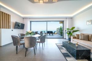 アギア・ペラギアにあるHilltop Luxury Villas with Private Pool and Sea Viewのテーブルと椅子とソファのあるリビングルーム
