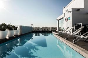 a swimming pool with chairs on a building at Hotel Juliani - Boutique Hotel in St Julian's