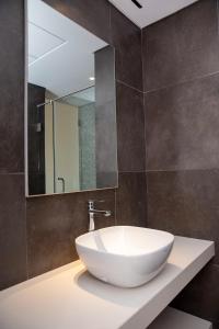 łazienka z białą umywalką i lustrem w obiekcie Maison Paraíso, apartamento de lujo 1Hab w mieście Ciudad de Malabo