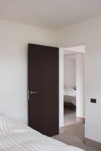 a bedroom with a black door leading to a bed at Villa Kint in Damme