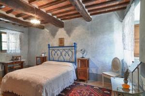 ein Schlafzimmer mit einem blauen Bett und einem Tisch in der Unterkunft AGRITURISMO Casale Il Caggio in Ciggiano + 66 Fotos