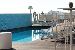 a swimming pool with chairs and a table and a table and chairsitures at Hotel Juliani - Boutique Hotel in St. Julianʼs