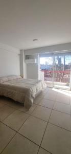 a bedroom with a bed on a tiled floor at Monoambiente Montevideo in Rosario
