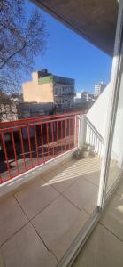 a balcony with a red railing on a building at Monoambiente Montevideo in Rosario