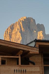 a building with a mountain in the background at La Tambra - Hotel Lodge in Santa Cristina in Val Gardena