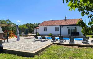 a yard with chairs and a pool and a house at Three-Bedroom Holiday Home In Vinjani Gornji in Aračići