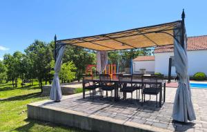 a patio with a table and chairs under a canopy at Three-Bedroom Holiday Home In Vinjani Gornji in Aračići +17 photos