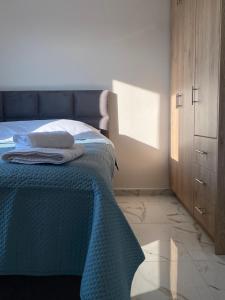 a bedroom with a bed with a blue blanket on it at Villa Amalia in Kriezá +6 photos