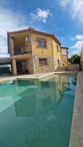 a large swimming pool in front of a house at Casa Flor de La Jara - An elegant rural retreat in Cobisa