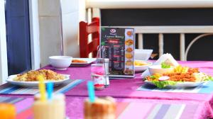 a pink table with plates of food on it at PEARL EXPRESS HOTEL KABALE ltd in Kabale