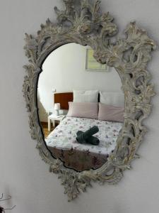 a mirror on a wall with a bed in a room at El Rincón del Pisuerga con Terraza in Cabezón de Pisuerga