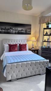 a bedroom with a large white bed with red pillows at The Bush Residence, Shepperton - Two Ground Floor Guest Bedrooms in Shepperton