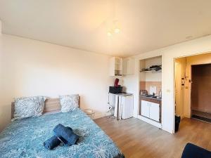Un dormitorio con una cama con una colcha azul. en Studio pour 2 près de la gare, en Melun 49 fotos más