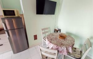 a dining room with a table and a refrigerator at Stunning Apartment In Senj With Kitchen in Starigrad