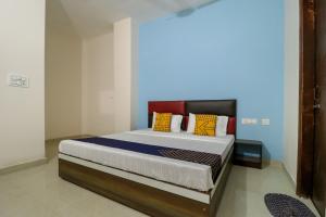 Un dormitorio con una cama grande con almohadas de colores. en Hotel O kalra, en Zirakpur
