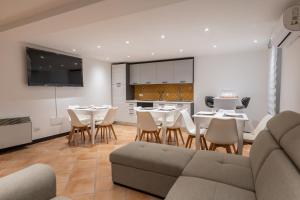 a living room with a couch and tables and chairs at Alcantara Domus in Roccella Valdemone