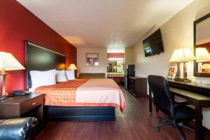 a hotel room with a bed and a desk at Regency Inn and Suites Bay City, Texas in Bay City