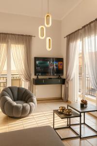a living room with a chair and a tv at FK Apartment Sea View Balcony 60 m to the Beach Near Athens Airport and Rafina Port in Artemida