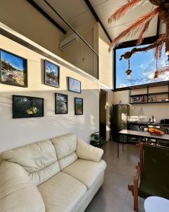 a living room with a white couch and a large window at Chale Baru - AC - rio e ofuro - Cavalcante in Teresina de Goias