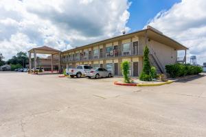 a building with cars parked in a parking lot at Regency Inn and Suites Bay City, Texas in Bay City