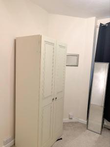 a white cabinet in a room with a mirror at Furnished double room in Johnstone
