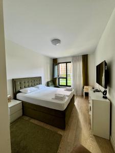 Un dormitorio con una cama grande y un televisor. en Belgrade Waterfront Carmen, en Belgrado
