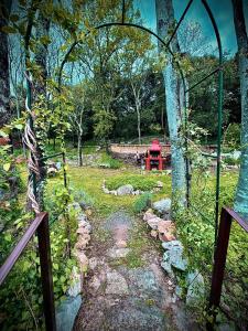 a garden with an archway and a stone path at Le petit coin de Paradis in Brissac