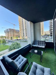 Una sala de estar con sofás y una gran ventana. en Belgrade Waterfront Carmen, en Belgrado