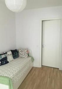 Una habitación blanca con una cama con almohadas y una puerta. en rooms WC separate, TV, en Bečići