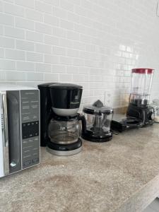 a kitchen counter with a coffee maker and a blender at Apartamento Paraiso Búzios l in Búzios
