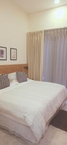 a bedroom with a large white bed and a window at CASA DON JULIAN in Oaxaca City