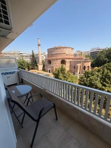 a balcony with a table and a chair and a building at ROTONDA SKG in Thessaloniki