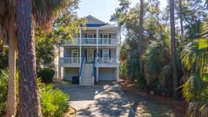 a house surrounded by palm trees with a porch at Spacious 4-Bed, 4-Bath Home in the heart of Fripp Island in Fripp Island