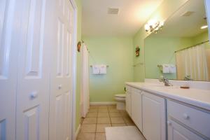 a bathroom with a sink and a toilet and a mirror at Spacious 4-Bed, 4-Bath Home in the heart of Fripp Island in Fripp Island +35 photos