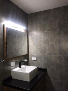a bathroom with a white sink and a mirror at Habitación con baño privado en casa compartida in Cochabamba +1 photo